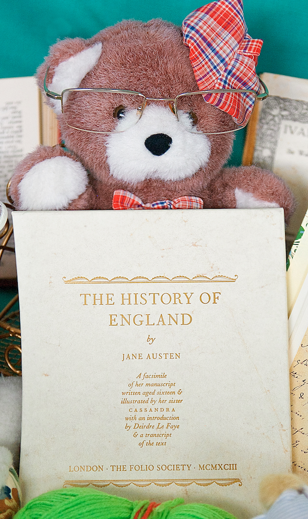 Bonnet Bear holds up a copy of Jane Austen's History of England