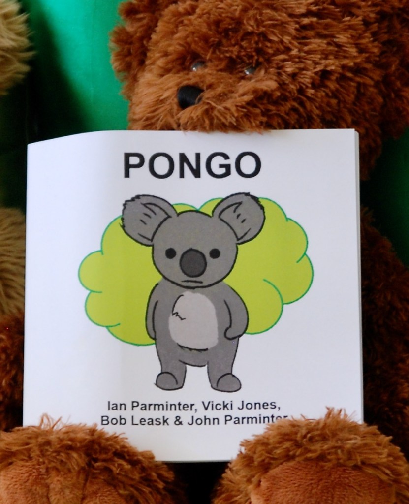 Teddy bear Caddy holds the book Pongo showing the cover 